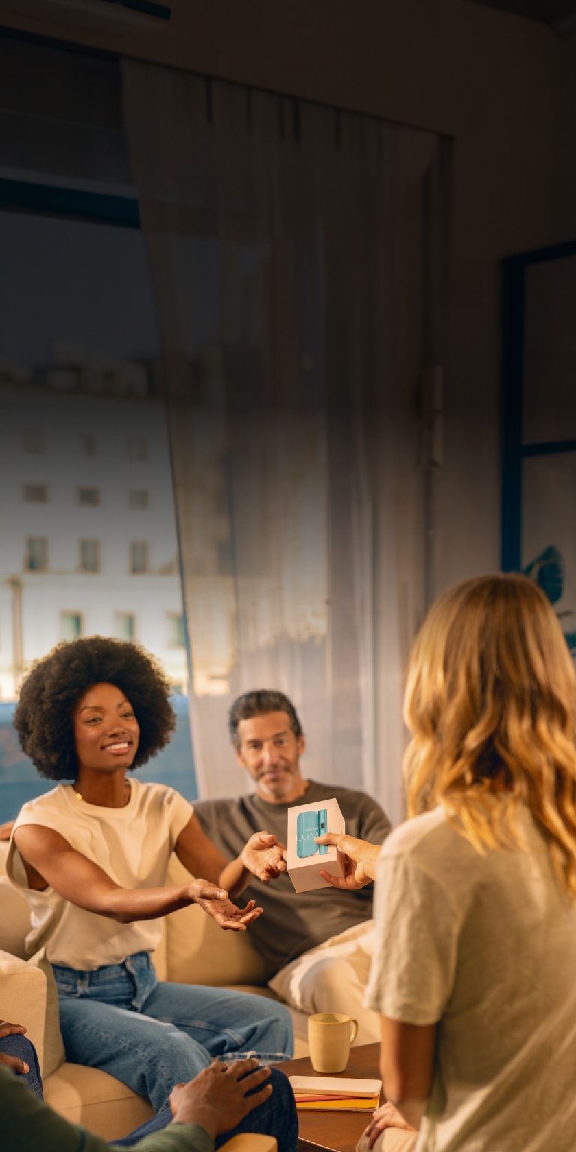 Group of people with a woman showing an IQOS ILUMA i device package