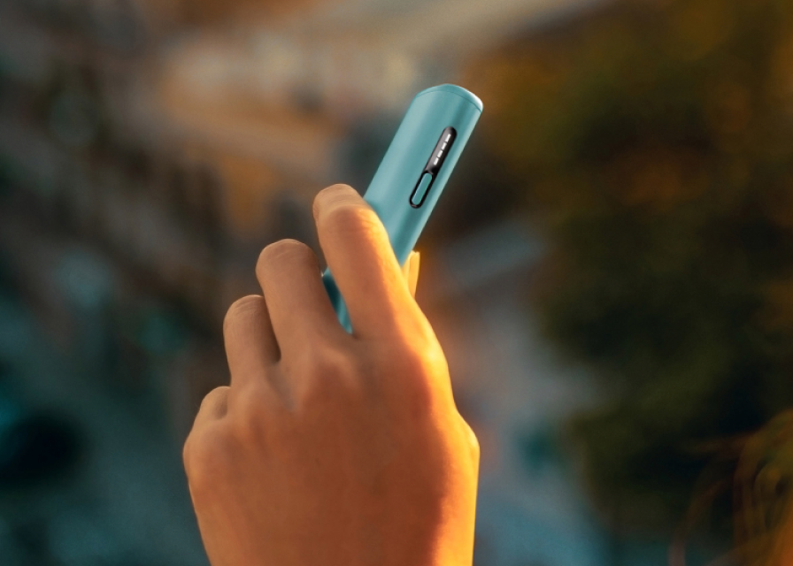 Χέρι κρατάει μια συσκευή IQOS ILUMA i ONE σε χρώμα Breeze Blue.