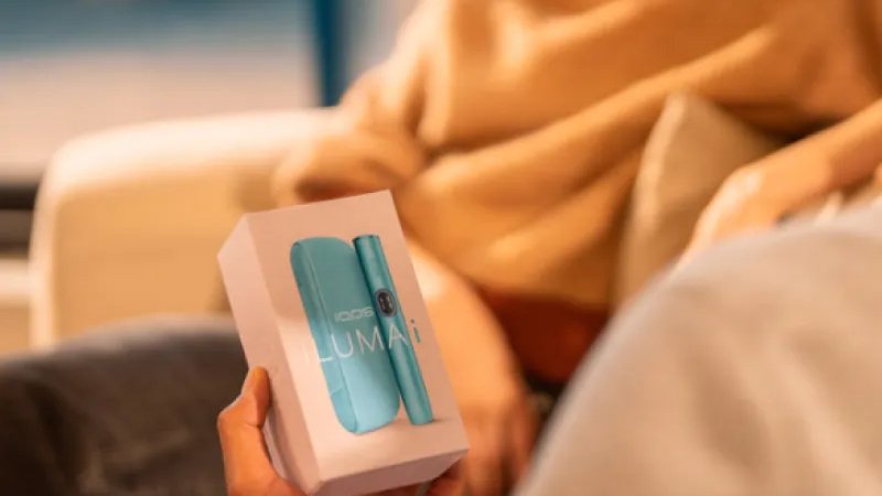 A woman opening a package from IQOS.
