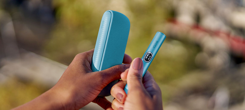 Woman holds IQOS ILUMA i Breeze Blue