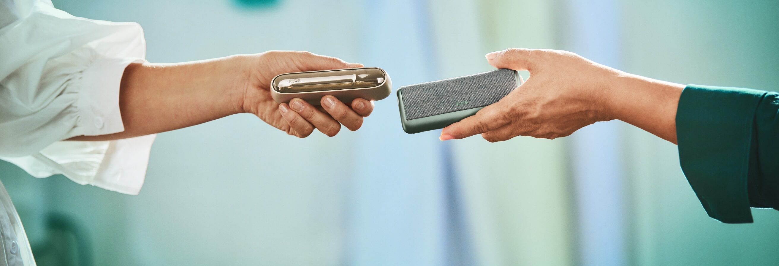 hands holding iqos devices