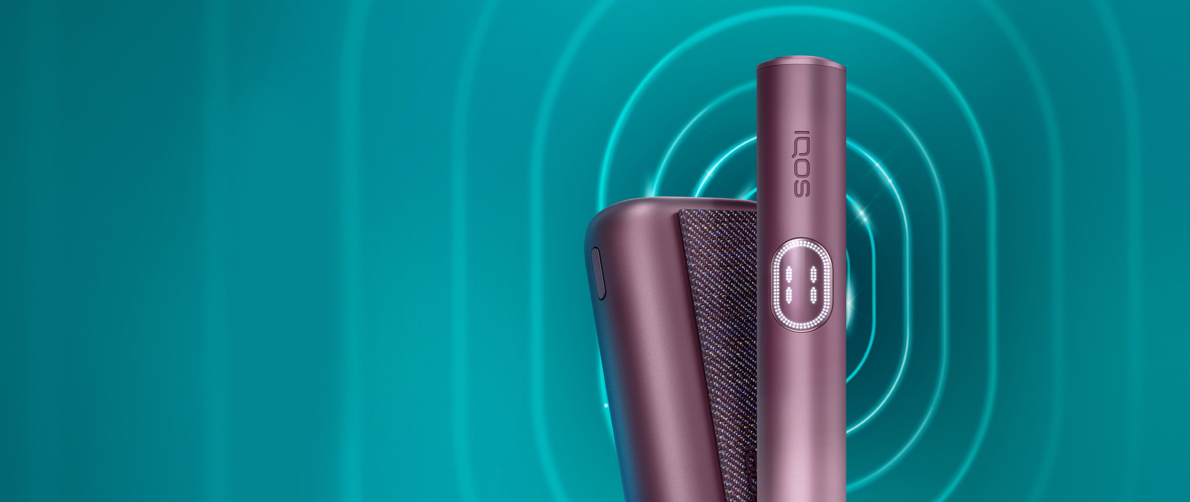 Συσκευή IQOS ILUMA i PRIME σε χρώμα Garnet Red και ο φορτιστής της σε σκούρο τιρκουάζ φόντο