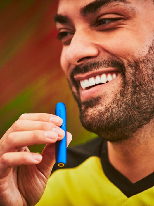 A man using a blue IQOS device.