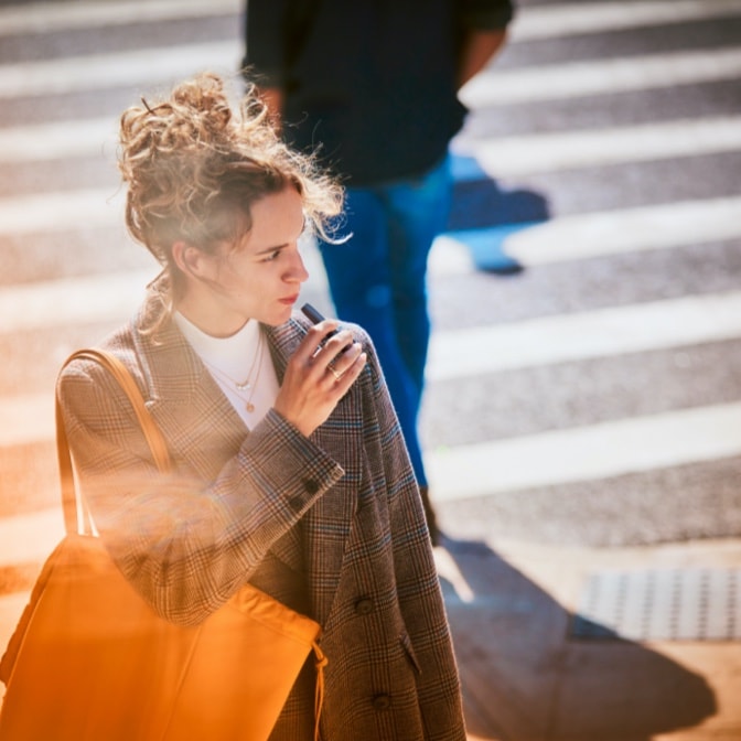Woman on the street using an IQOS holder