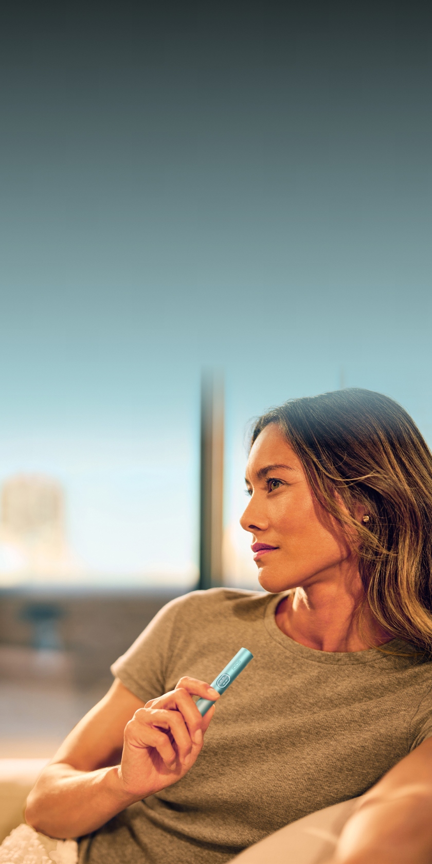 Woman holding an IQOS ILUMA device