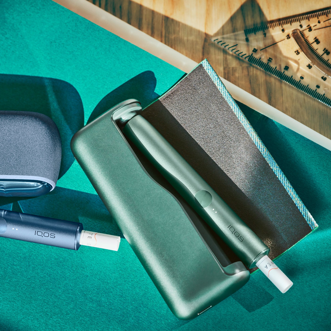 Μία συσκευή IQOS ILUMA σε χρώμα Jade Green πάνω σε ένα γραφείο.