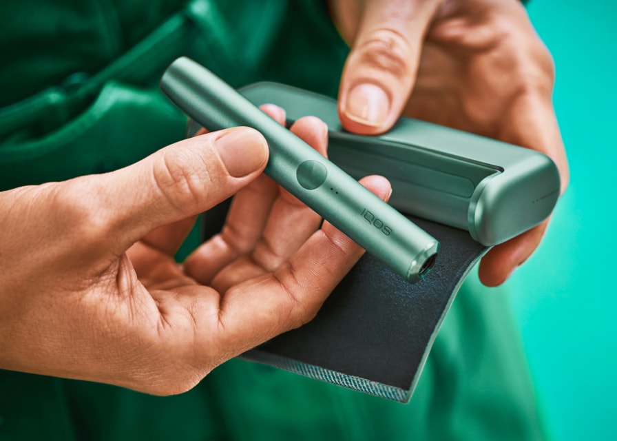IQOS ILUMA PRIME συσκευή σε χρώμα jade green στα χέρια ενός αρχιτέκτονα
