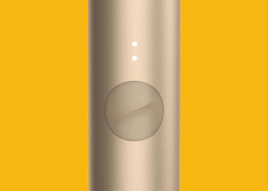 Close up of a brilliant gold IQOS device.