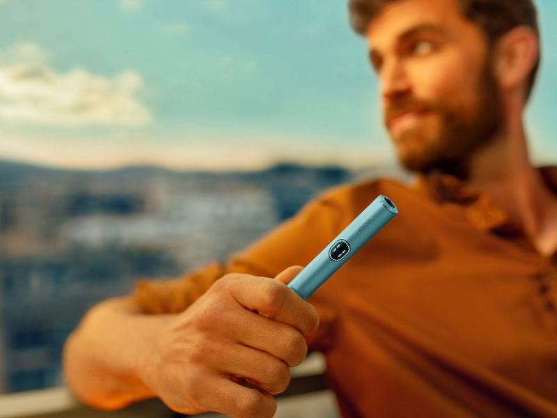 Man holding a Breeze Blue IQOS ILUMA i device