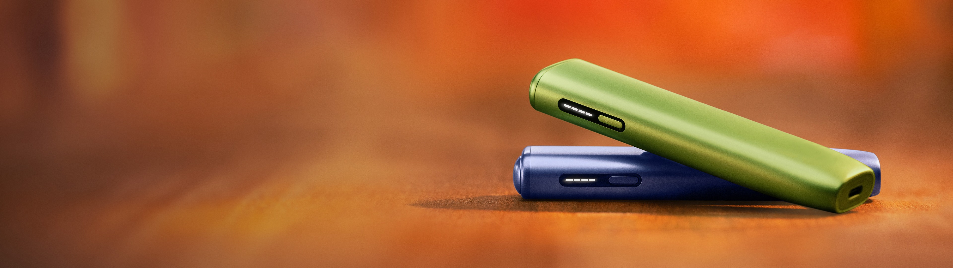 Green IQOS ILUMA i ONE above a violet IQOS ILUMA i ONE