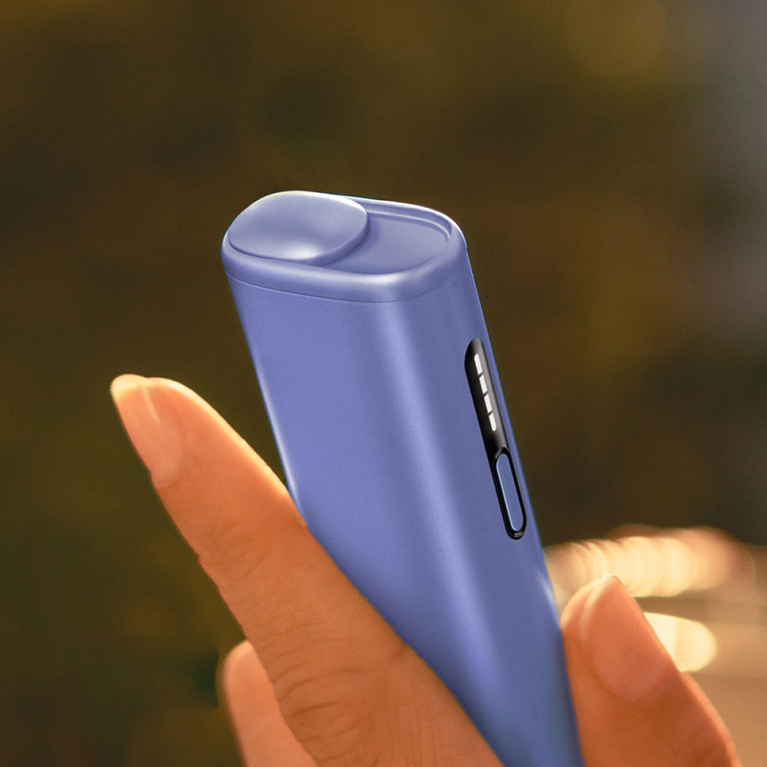 IQOS ILUMA i device being picked out of its charger, with customed sleeve and ring