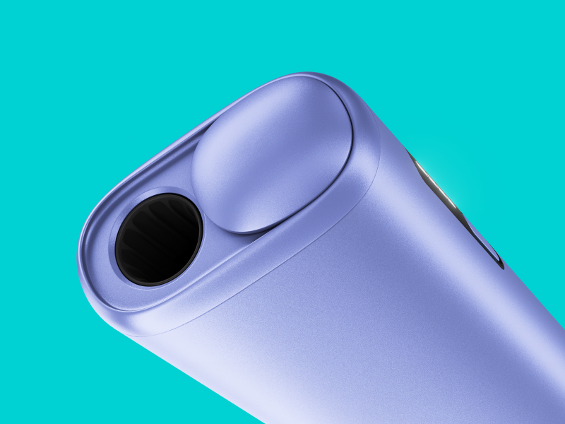 Black IQOS ILUMA i PRIME device and its charger on a light turquoise background