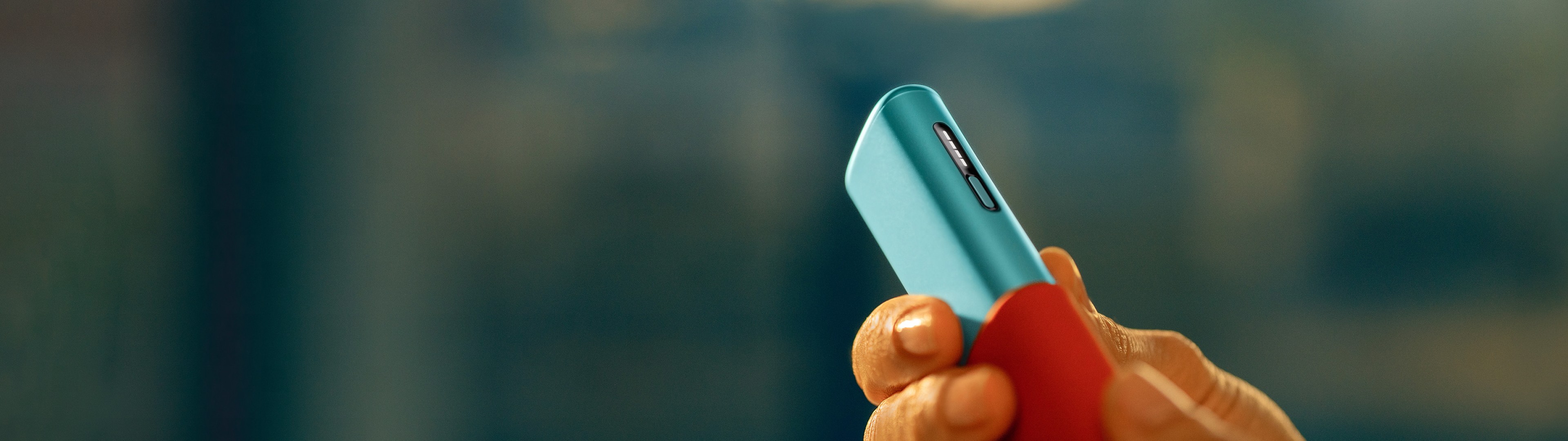Hand holding together an IQOS ILUMA i ONE and a sleeve