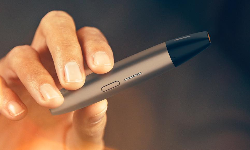 Ένα χέρι που δείχνει ένα χρυσό IQOS VEEV