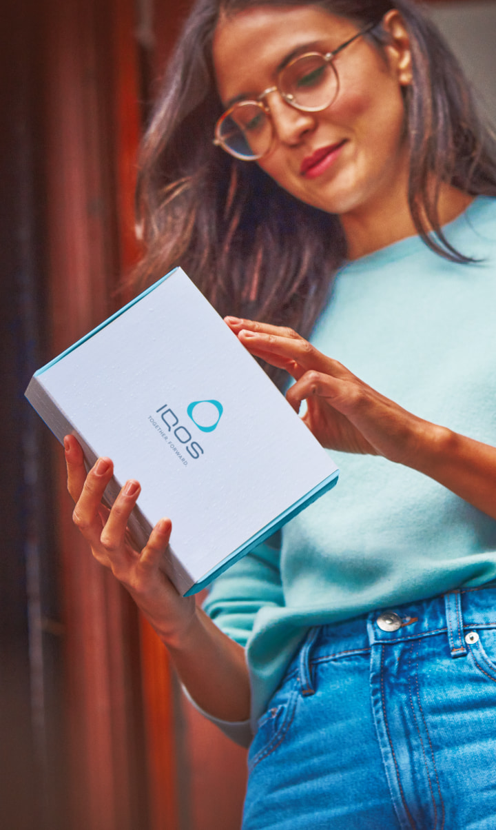 woman holding an IQOS gift box