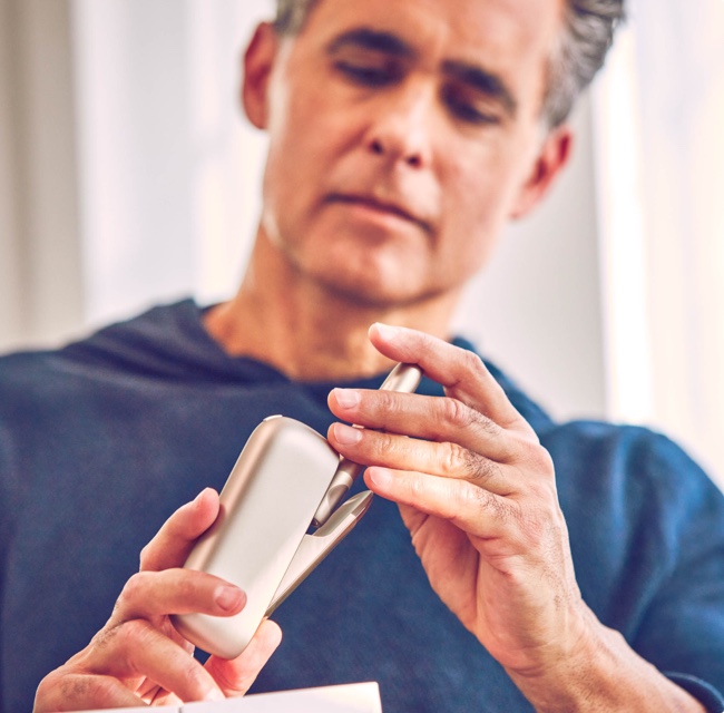 Person holding an IQOS device.