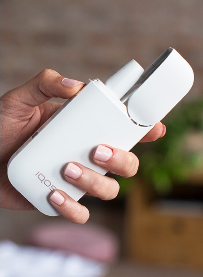 Woman holding her grey IQOS - IQOS charging slowly