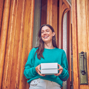 Girl smiling with an IQOS box in her hands
