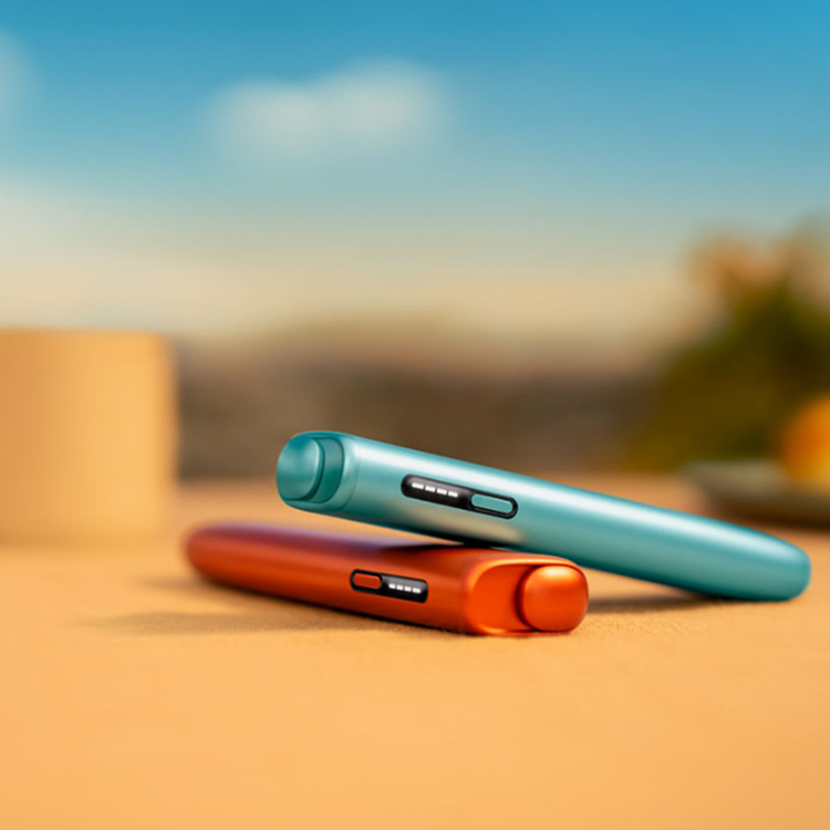 Two IQOS ILUMA i ONE devices. One Terracotta Red and the other Breeze Blue Two IQOS ILUMA i ONE devices. One Terracotta Red and the other Breeze Blue