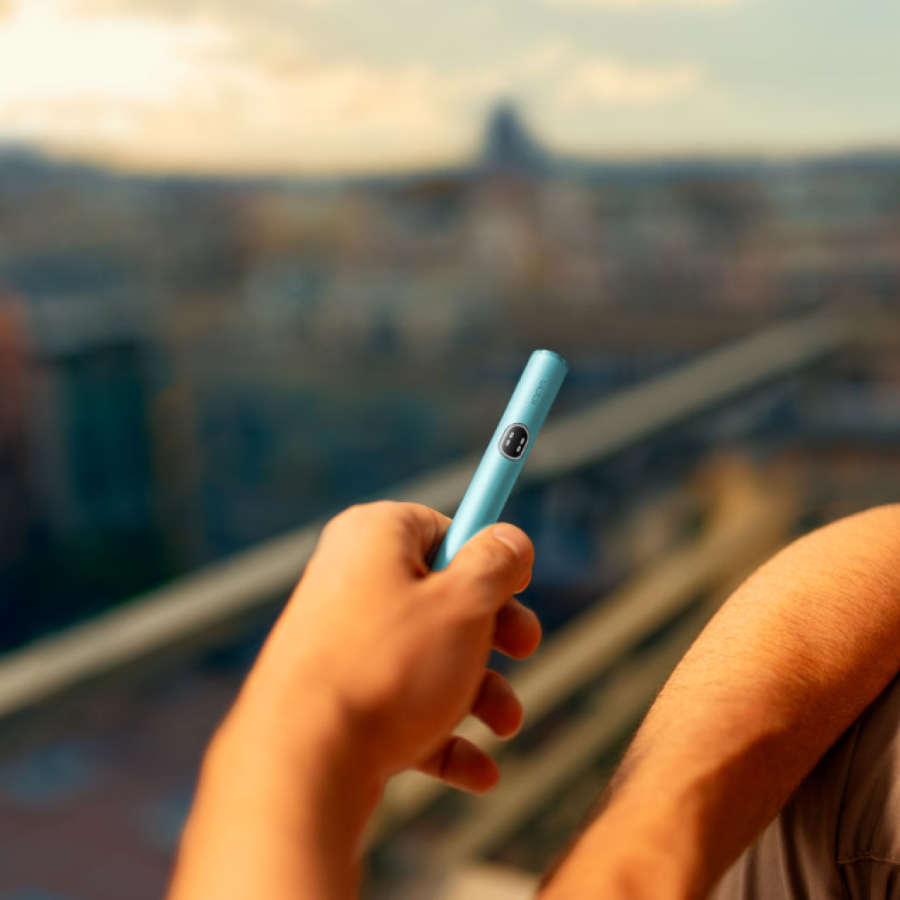 Male hand holding a Terracotta IQOS ILUMA i ONE device.