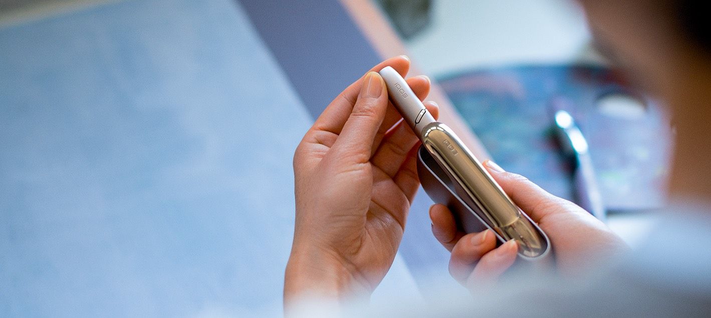 χέρι βγάζει βάση IQOS 3 DUO από τον φορτιστή τσέπης χέρι βγάζει βάση IQOS 3 DUO από τον φορτιστή τσέπης