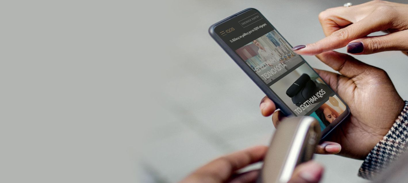 γυναίκα περιηγείται στο site του IQOS από το κινητό της γυναίκα περιηγείται στο site του IQOS από το κινητό της