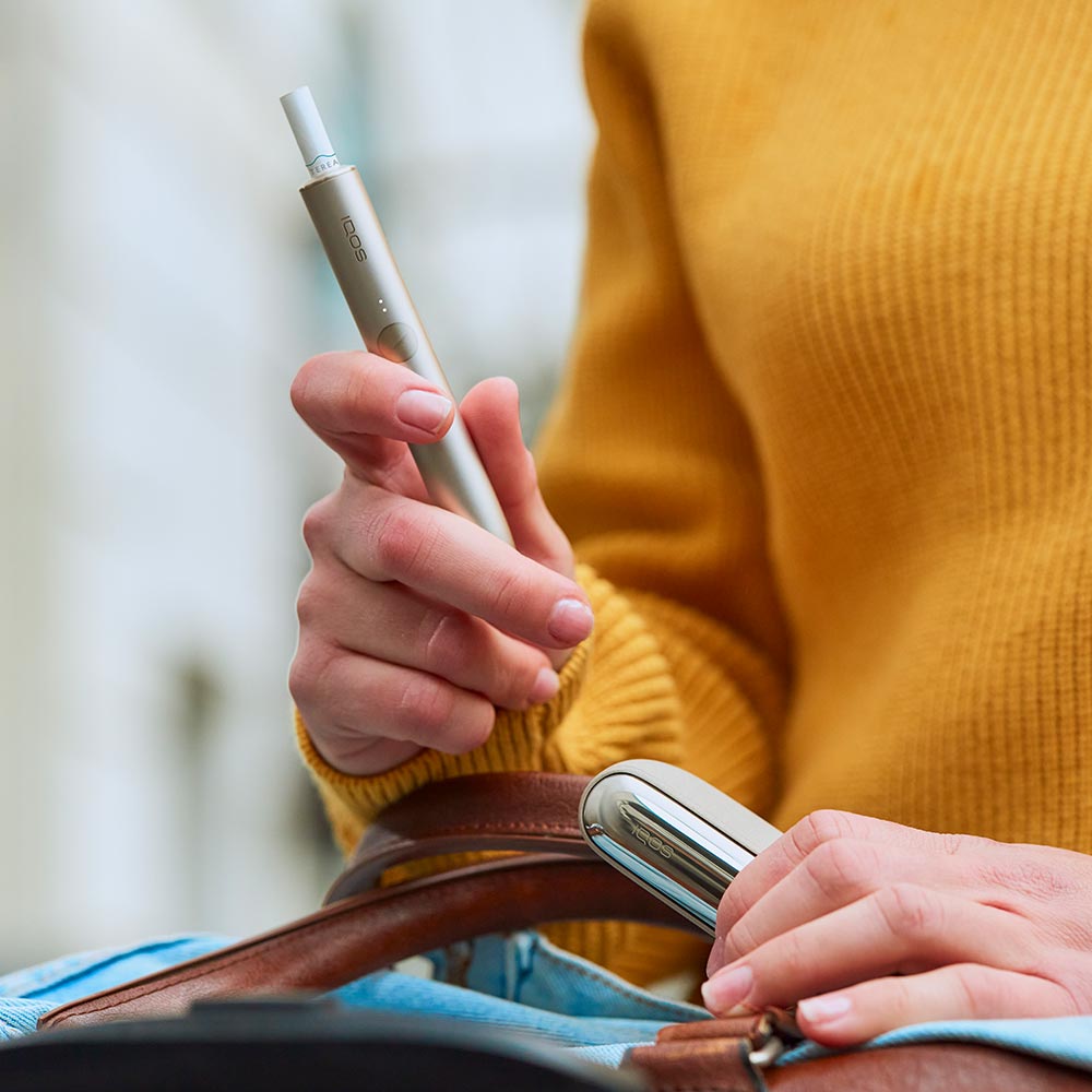 woman holding a white IQOS 3 DUO