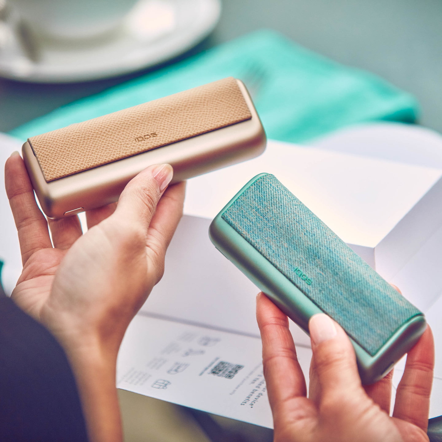 A man's hands opening an IQOS ILUMA device.